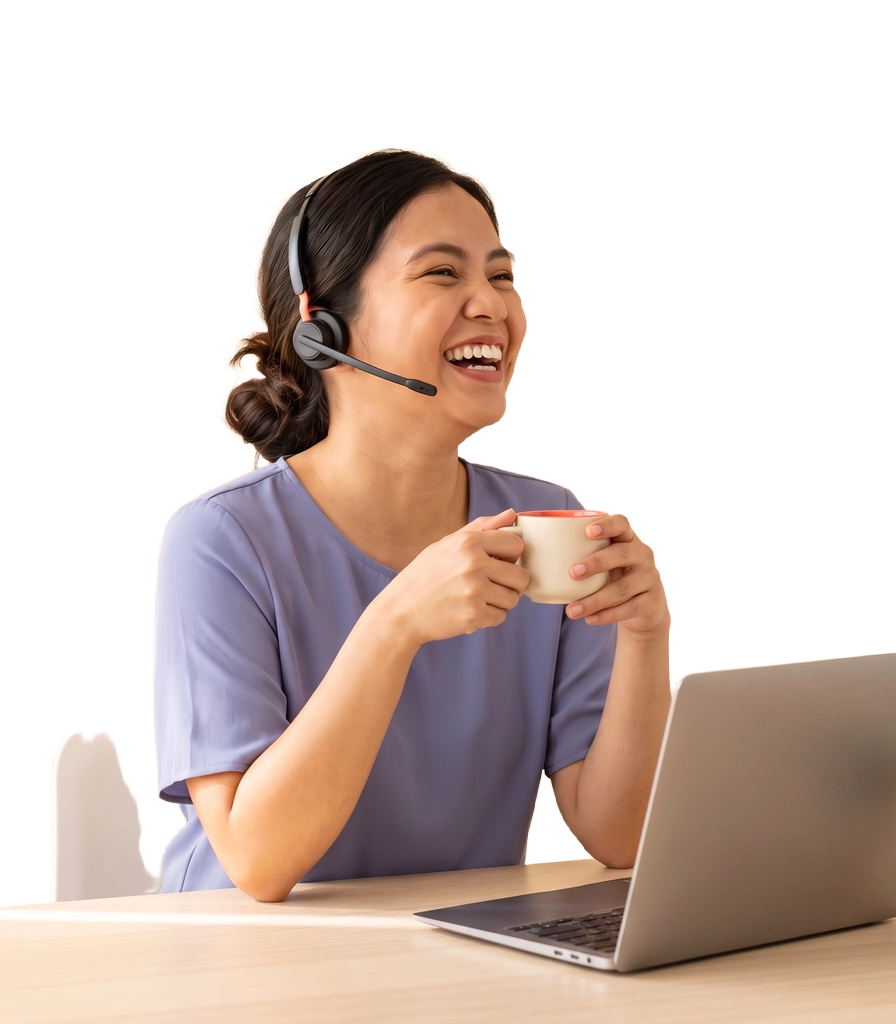 A Filipina virtual assistant laughing, headset on, holding a mug at her desk with an open laptop